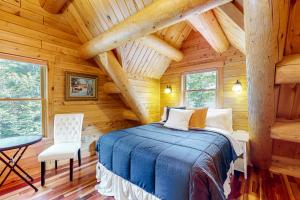 a bedroom in a log cabin with a bed and a chair at Tranquil Haven in Greenville