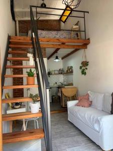 sala de estar con escalera de caracol y sofá en Loft en Las Flores, en Las Flores