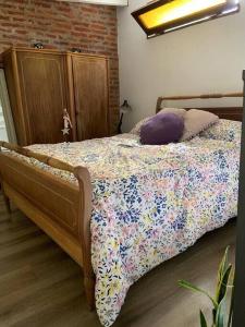 a bedroom with a bed with a floral comforter at Loft en Las Flores in Las Flores