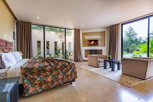 a bedroom with a large bed and a fireplace at Villa Tomazo in Marrakech