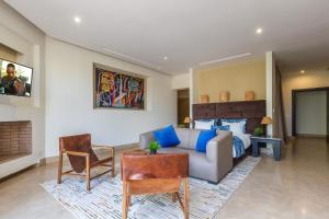 a bedroom with a bed and a couch and a table at Villa Tomazo in Marrakech