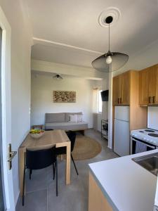 a kitchen and living room with a table and a dining room at Thassa Beach Apartment No1 (with mountain view) in Leonidion