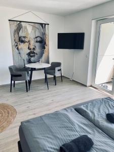 una sala de estar con una mesa y una pintura en la pared en Flat - WiFi + SmartTV + Balcony en Sankt Augustin