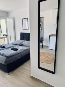 a mirror in a room with a bed and a bed sqor at Flat - WiFi + SmartTV + Balcony in Sankt Augustin