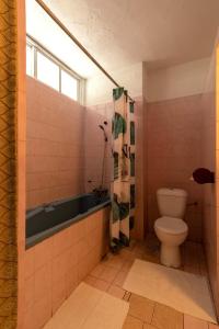 a bathroom with a bath tub and a toilet at Hostellerie de la Sanaga in Edéa +42 photos