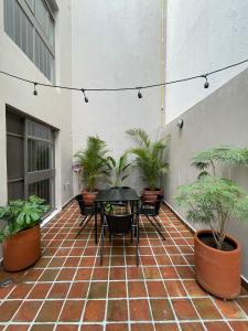 d'une terrasse avec une table et des plantes en pot. dans l'établissement Casa San Fernando by Barrio México, à Guadalajara