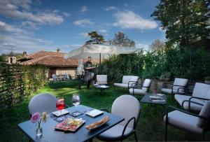 a woman standing in a garden with a table and chairs at Centro Storico in Neviglie