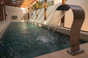 a pool with a water fountain in a building at Villa Hotel in Rio Piracicaba