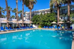 a swimming pool with chairs and palm trees at Sami Beach Hotel- All Inclusive in Gümbet