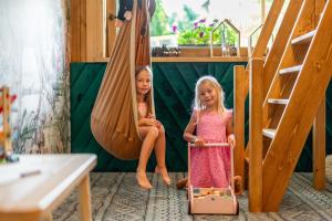 Zwei kleine Mädchen sitzen auf einer Schaukel in der Unterkunft Rezydencja Górska Odkryj Zakopane in Zakopane