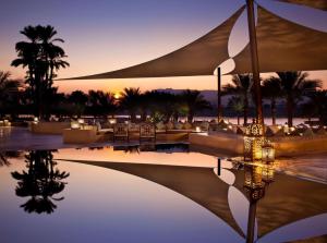 a resort with a reflection in a pool of water at Hilton Luxor Resort & Spa in Luxor