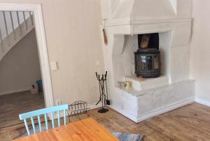 a fireplace in a living room with a table and chairs at Berggården Vandrarhem in Gnarp