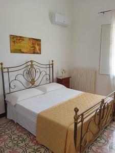 um quarto com uma cama grande e lençóis brancos em La chiccara del Bar Natale em Nardò