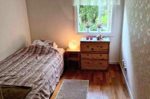 ein Schlafzimmer mit einem Bett, einer Kommode und einem Fenster in der Unterkunft Berggården Vandrarhem in Gnarp