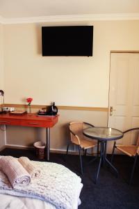 Ein Zimmer mit einem Schreibtisch, einem Tisch und einem Tisch sidx sidx sidx. in der Unterkunft Victoria Heights B&B in George