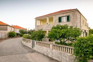 une maison avec une clôture en pierre en face d'une rue dans l'établissement Apartment near the beach- Zen 2, à Brna