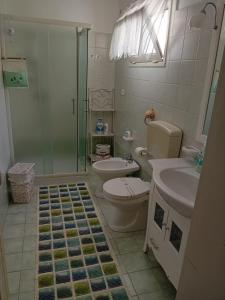 uma casa de banho com um chuveiro, um WC e um lavatório. em La chiccara del Bar Natale em Nardò
