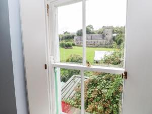 une fenêtre ouverte avec vue sur une maison dans l'établissement Bwthyn Berwig, à Swansea