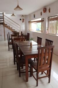 uma sala de jantar com uma mesa de madeira e cadeiras em Pousada Recôncavo em São Félix