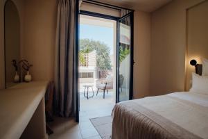 a bedroom with a bed and a sliding glass door at Thymises Boutique Hotel in Kakopetria