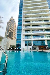 una gran piscina frente a un edificio en Veluxa - Designer 1 Bedroom with Sea View!, en Dubái