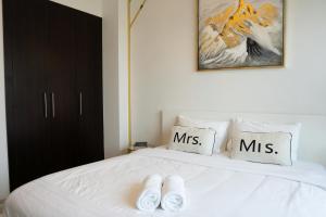 un par de zapatillas blancas sentadas encima de una cama en Veluxa - Designer 1 Bedroom with Sea View!, en Dubái