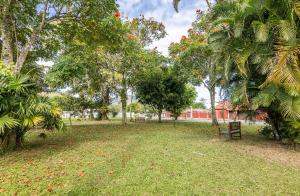un parque con un banco y árboles y un edificio en Suíte 101- Espaço Praia Aptos, en Angra dos Reis