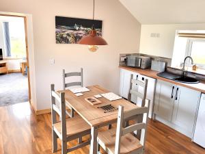 a kitchen and dining room with a wooden table and chairs at Reka Vik in Stromness
