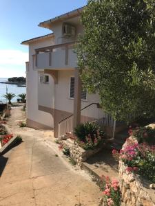 a house with flowers in front of it at Apartments and rooms LJUBICA in Lun