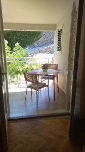 a table and two chairs on a balcony with a table at Apartments and rooms LJUBICA in Lun