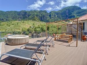 a deck with chairs and a fire pit and mountains at Villa Teresa by Atlantic Holiday in São Vicente