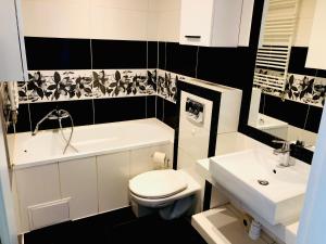 a bathroom with a toilet and a tub and a sink at Mieszkanie z ogródkiem in Wrocław +11 photos
