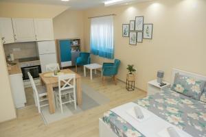 Zimmer mit einem Bett und einer Küche mit einem Tisch in der Unterkunft Vila Harmony in Pirot