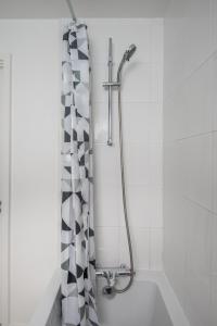 a shower in a bathroom with a black and white shower curtain at Stunning 2Bed BRICK LANE Apartment in London