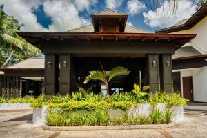 ein Resortgebäude mit Pflanzen davor in der Unterkunft Hilton Seychelles Northolme Resort & Spa in Beau Vallon
