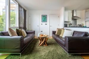 a living room with two leather couches and a table at Stunning 2Bed BRICK LANE Apartment in London