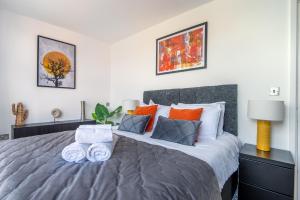 a bedroom with a large bed with orange and white pillows at Stunning 2Bed BRICK LANE Apartment in London