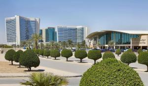 eine Straße mit Bäumen und Gebäuden in einer Stadt in der Unterkunft Hilton Riyadh Hotel & Residences in Riad
