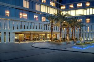 un edificio de oficinas con palmeras delante en Hilton Riyadh Hotel & Residences, en Riad