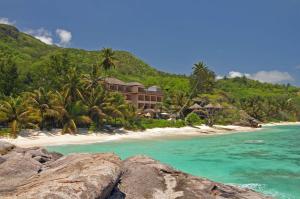 un complejo en una playa con palmeras y el océano en DoubleTree by Hilton Seychelles Allamanda Resort & Spa, en Takamaka