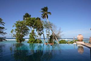 uma piscina com vista para o oceano em DoubleTree by Hilton Seychelles Allamanda Resort & Spa em Takamaka