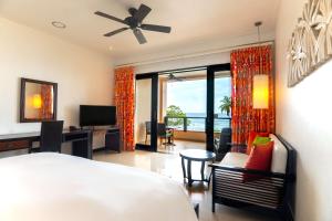 a bedroom with a bed and a desk and a television at DoubleTree by Hilton Seychelles Allamanda Resort & Spa in Takamaka