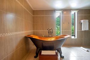 una gran bañera de madera en un baño con ventana en DoubleTree by Hilton Seychelles Allamanda Resort & Spa, en Takamaka