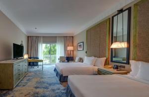 a hotel room with two beds and a television at Hilton Salalah Resort in Salalah