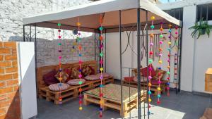 eine Veranda mit einem Pavillon und einer Schaukel in der Unterkunft JUMANA in Nazca