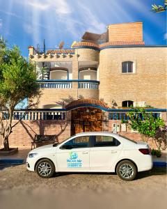 a white car parked in front of a house at BLUE WAVE LODGE in Imi Ouaddar