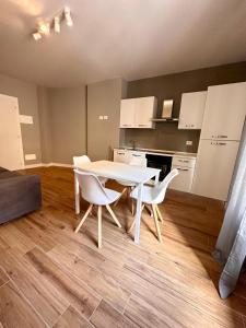 uma cozinha com uma mesa branca e cadeiras num quarto em HH Hermoso Housing ALESSANDRIA em Alessandria