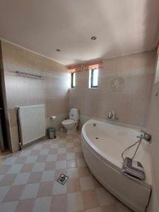 łazienka z dużą wanną i toaletą w obiekcie Lio's Villa w mieście Xilokéra