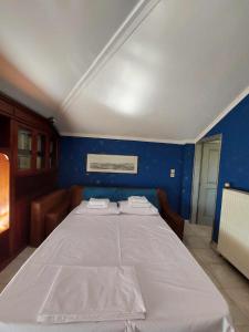 a large bed in a room with a blue wall at Lio's Villa in Xilokéra