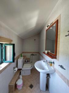 W łazience znajduje się umywalka, toaleta i lustro. w obiekcie Lio's Villa w mieście Xilokéra